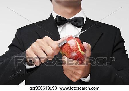 Stock Photo - Mid section view of a waiter peeling an apple. Fotosearch