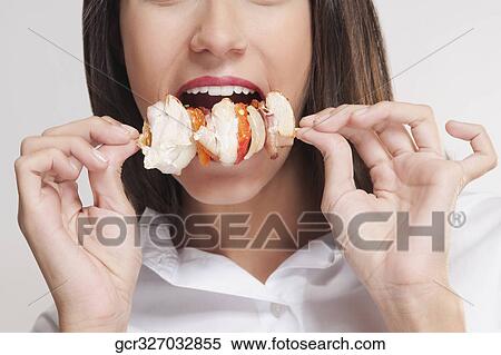 Mid section view of a woman eating a shish kebab View Large Photo Image Stock Photography - Mid section view of a woman eating a shish kebab. Fotosearch