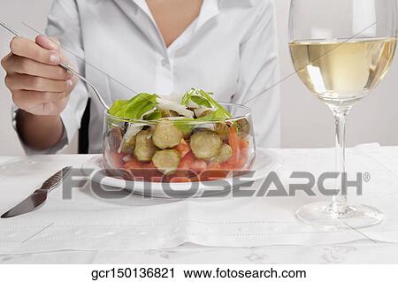 Mid section view of a woman eating salad View Large Photo Image Stock Image - Mid section view of a woman eating salad. Fotosearch