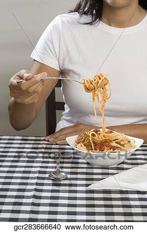 Mid section view of a woman eating spaghetti View Large Photo Image Stock Image - Mid section view of a woman eating spaghetti. Fotosearch