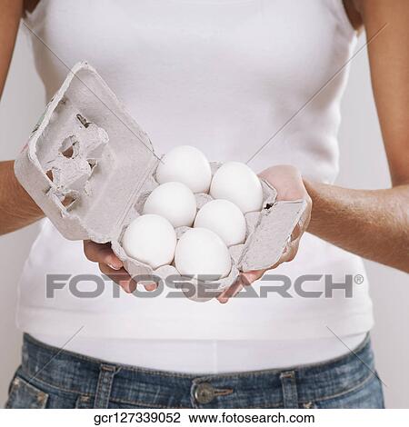 Mid section view of a woman holding a carton of eggs View Large Photo Image Stock Image - Mid section view of a woman holding a carton of eggs. Fotosearch