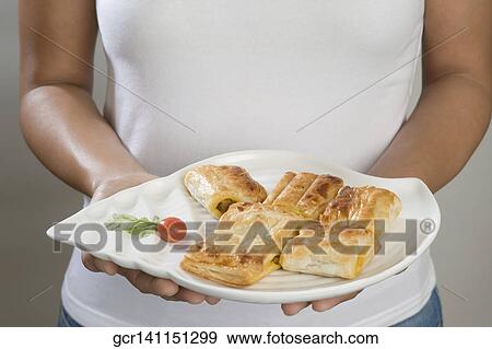 Mid section view of a woman holding a platter of baked puffs View Large Photo Image Stock Photo - Mid section view of a woman holding a platter of baked puffs. Fotosearch
