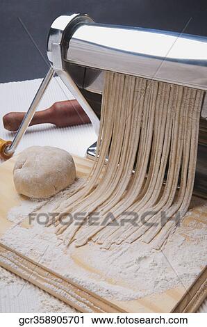 Pasta being cut with a pasta maker View Large Photo Image Stock Image - Pasta being cut with a pasta maker. Fotosearch