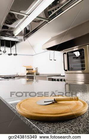 Pizza cutter on a cutting board in the kitchen View Large Photo Image Stock Photo - Pizza cutter on a cutting board in the kitchen. Fotosearch