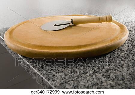 Pizza cutter on a cutting board View Large Photo Image Stock Photo - Pizza cutter on a cutting board. Fotosearch