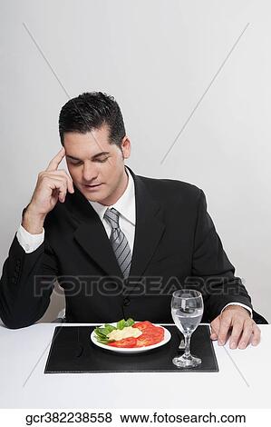 Stock Photo - Plate of salad in front of a businessman. Fotosearch