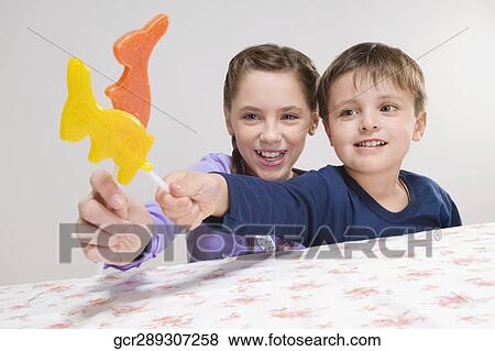Portrait of a boy and a girl holding animal shaped lollipops View Large Photo Image Stock Photo - Portrait of a boy and a girl holding animal shaped lollipops. Fotosearch