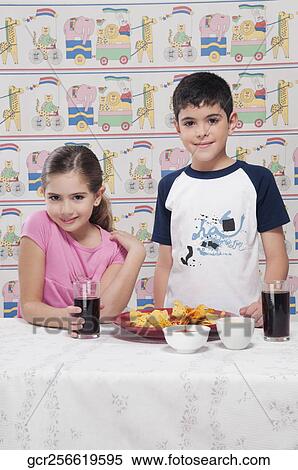 Stock Photography - Portrait of a boy and girl with a platter of nachos. Fotosearch