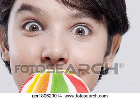 Portrait of a boy holding a lollipop View Large Photo Image Picture - Portrait of a boy holding a lollipop. Fotosearch