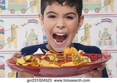 Portrait of a boy holding a platter of nachos and shouting in excitement View Large Photo Image Stock Image - Portrait of a boy holding a platter of nachos and shouting in excitement. Fotosearch