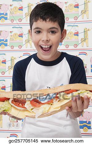 Portrait of a boy holding a submarine sandwich View Large Photo Image Stock Photography - Portrait of a boy holding a submarine sandwich. Fotosearch