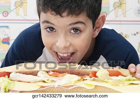 Portrait of a boy with a submarine sandwich View Large Photo Image Stock Photo - Portrait of a boy with a submarine sandwich. Fotosearch