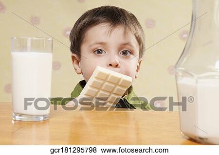 Portrait of a boy with a white chocolate bar and a glass of milk View Large Photo Image Stock Photo - Portrait of a boy with a white chocolate bar and a glass of milk. Fotosearch