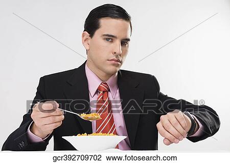 Portrait of a businessman eating cereal in a hurry View Large Photo Image Stock Image - Portrait of a businessman eating cereal in a hurry. Fotosearch