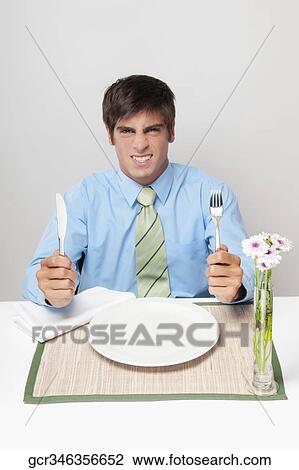Stock Image - Portrait of a businessman getting angry waiting for dinner. Fotosearch