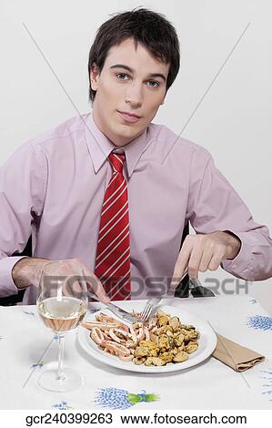 Stock Image - Portrait of a businessman having lunch. Fotosearch