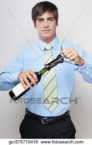 Portrait of a businessman opening a bottle of wine View Large Photo Image Stock Photograph - Portrait of a businessman opening a bottle of wine. Fotosearch