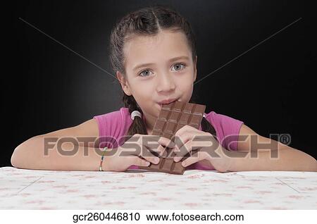 Portrait of a girl eating a bar of chocolate View Large Photo Image Stock Image - Portrait of a girl eating a bar of chocolate. Fotosearch