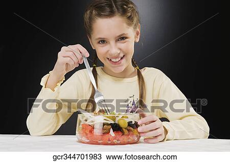 Portrait of a girl eating a bowl of salad View Large Photo Image Stock Image - Portrait of a girl eating a bowl of salad. Fotosearch