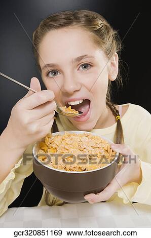 Portrait of a girl eating corn flakes View Large Photo Image Stock Photo - Portrait of a girl eating corn flakes. Fotosearch