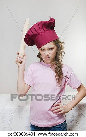 Portrait of a girl frowning with a rolling pin View Large Photo Image Stock Image - Portrait of a girl frowning with a rolling pin. Fotosearch