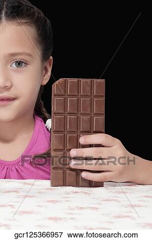 Stock Photo - Portrait of a girl holding a bar of chocolate. Fotosearch