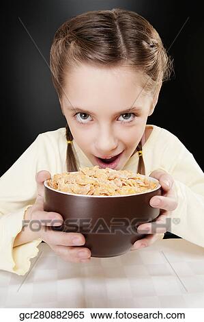 Portrait of a girl holding a bowl of corn flakes View Large Photo Image Stock Photography - Portrait of a girl holding a bowl of corn flakes. Fotosearch