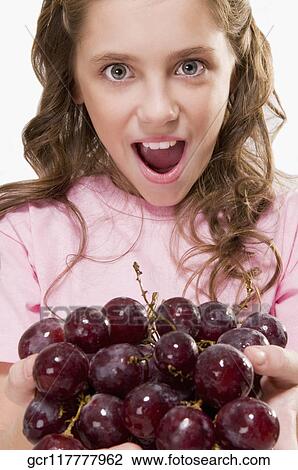 Portrait of a girl holding a bunch of grapes View Large Photo Image Stock Image - Portrait of a girl holding a bunch of grapes. Fotosearch