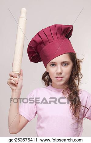 Stock Image - Portrait of a girl holding a rolling pin. Fotosearch