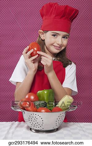Picture - Portrait of a girl holding a tomato. Fotosearch