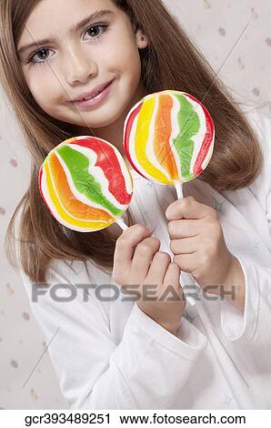 Portrait of a girl holding lollipops View Large Photo Image Stock Image - Portrait of a girl holding lollipops. Fotosearch