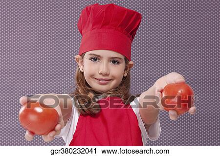 Stock Image - Portrait of a girl holding two tomatoes. Fotosearch