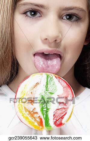Portrait of a girl licking a lollipop View Large Photo Image Stock Image - Portrait of a girl licking a lollipop. Fotosearch