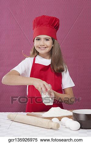 Stock Photography - Portrait of a girl putting flour on a chopping board. Fotosearch