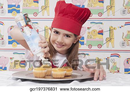 Portrait of a girl putting whipped cream on cupcakes View Large Photo Image Stock Image - Portrait of a girl putting whipped cream on cupcakes. Fotosearch