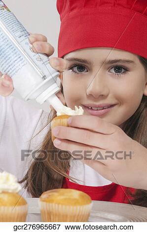 Portrait of a girl putting whipped cream on cupcakes View Large Photo Image Stock Photo - Portrait of a girl putting whipped cream on cupcakes. Fotosearch