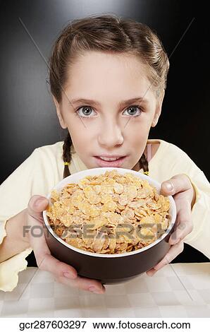 Portrait of a girl showing a bowl of corn flakes View Large Photo Image Stock Photo - Portrait of a girl showing a bowl of corn flakes. Fotosearch