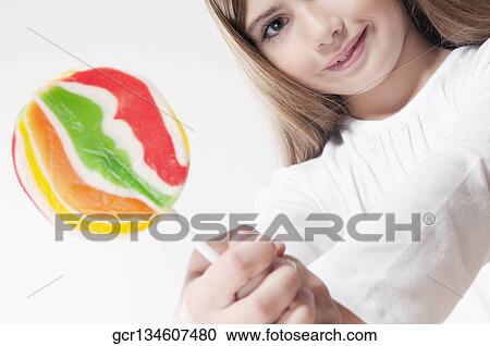 Portrait of a girl showing a lollipop View Large Photo Image Stock Image - Portrait of a girl showing a lollipop. Fotosearch