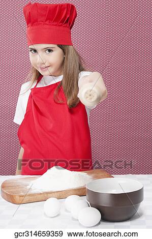 Stock Photo - Portrait of a girl showing a rolling pin. Fotosearch