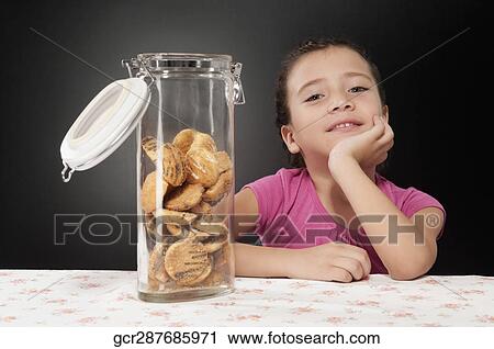 Portrait of a girl smiling behind a cookie jar View Large Photo Image Stock Image - Portrait of a girl smiling behind a cookie jar. Fotosearch