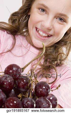 Portrait of a girl with a bunch of grapes View Large Photo Image Stock Photo - Portrait of a girl with a bunch of grapes. Fotosearch