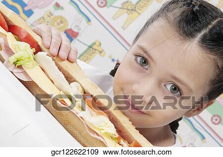 Portrait of a girl with a submarine sandwich View Large Photo Image Stock Photo - Portrait of a girl with a submarine sandwich. Fotosearch