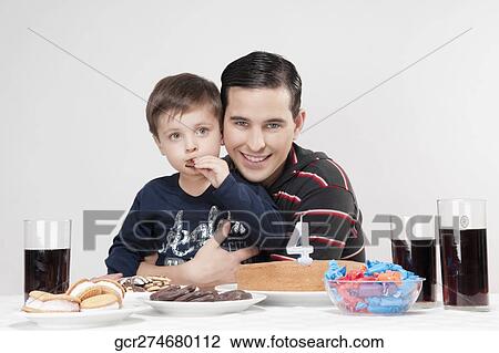 Portrait of a man and his son with a birthday cake in front of them View Large Photo Image Stock Image - Portrait of a man and his son with a birthday cake in front of them. Fotosearch