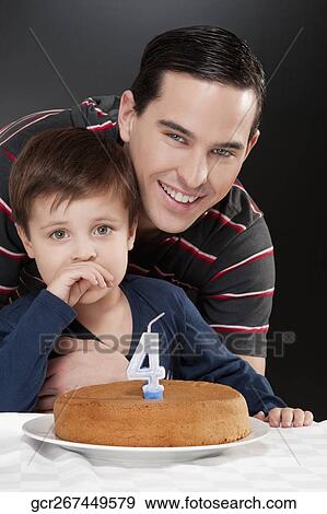 Portrait of a man and his son with a birthday cake in front of them View Large Photo Image Stock Photo - Portrait of a man and his son with a birthday cake in front of them. Fotosearch