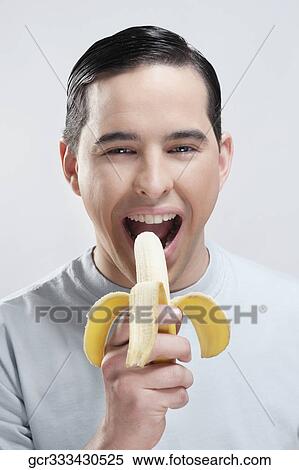 Stock Photography - Portrait of a man eating a banana. Fotosearch