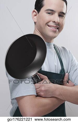 Portrait of a man holding a frying pan and smiling View Large Photo Image Stock Image - Portrait of a man holding a frying pan and smiling. Fotosearch