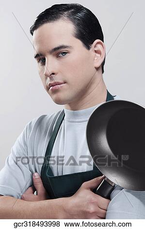 Stock Photo - Portrait of a man holding a frying pan. Fotosearch
