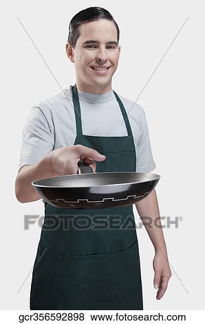 Portrait of a man holding a frying pan and smiling View Large Photo Image Stock Photo - Portrait of a man holding a frying pan and smiling. Fotosearch