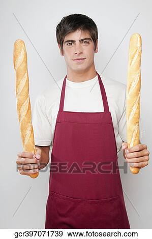 Portrait of a man holding baguettes in both hands View Large Photo Image Stock Photo - Portrait of a man holding baguettes in both hands. Fotosearch