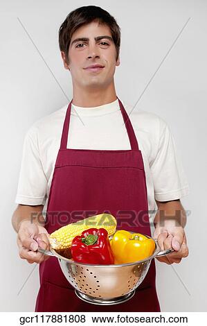 Portrait of a man holding vegetables in a strainer View Large Photo Image Stock Photo - Portrait of a man holding vegetables in a strainer. Fotosearch
